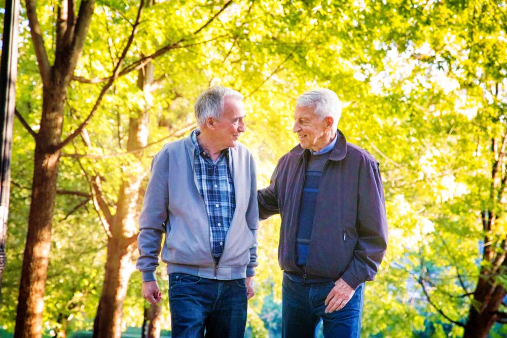 2 retired men walking in the park