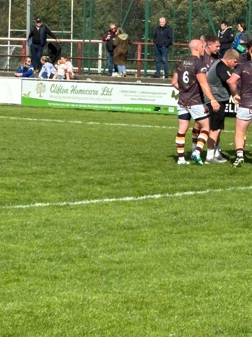 Clifton Homecare Fylde Rugby Players  in front of Pitchside Board